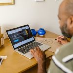 Empreendedor trabalha em um laptop à mesa, em um ambiente de escritório.