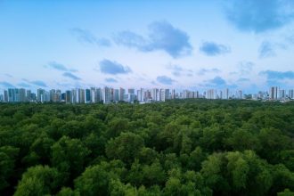 Vista aérea de Fortaleza, com a paisagem urbana integrada a uma área de vegetação.