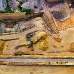 Vista aérea de uma pedreira com máquinas trabalhando na extração e no processamento de materiais minerais